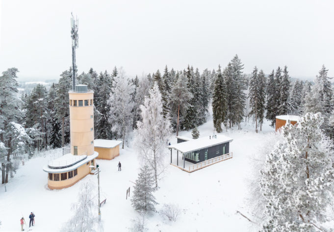 Talvinen ilmakuva Kirkkoharjun näkötornista ja ympäristöstä. Tornin juurella näkyy joitakin hiihtäjiä.