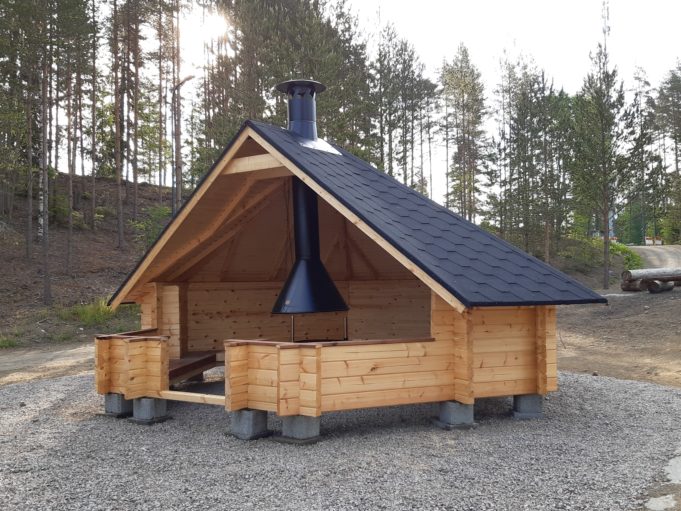 Puinen kotalaavu aukiolla, jonka takana näkyy metsää.