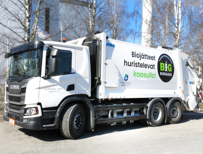 Valkoinen jäteauto, jonka kyljessä lukee "Biojätteet huristelevat kaasulla".