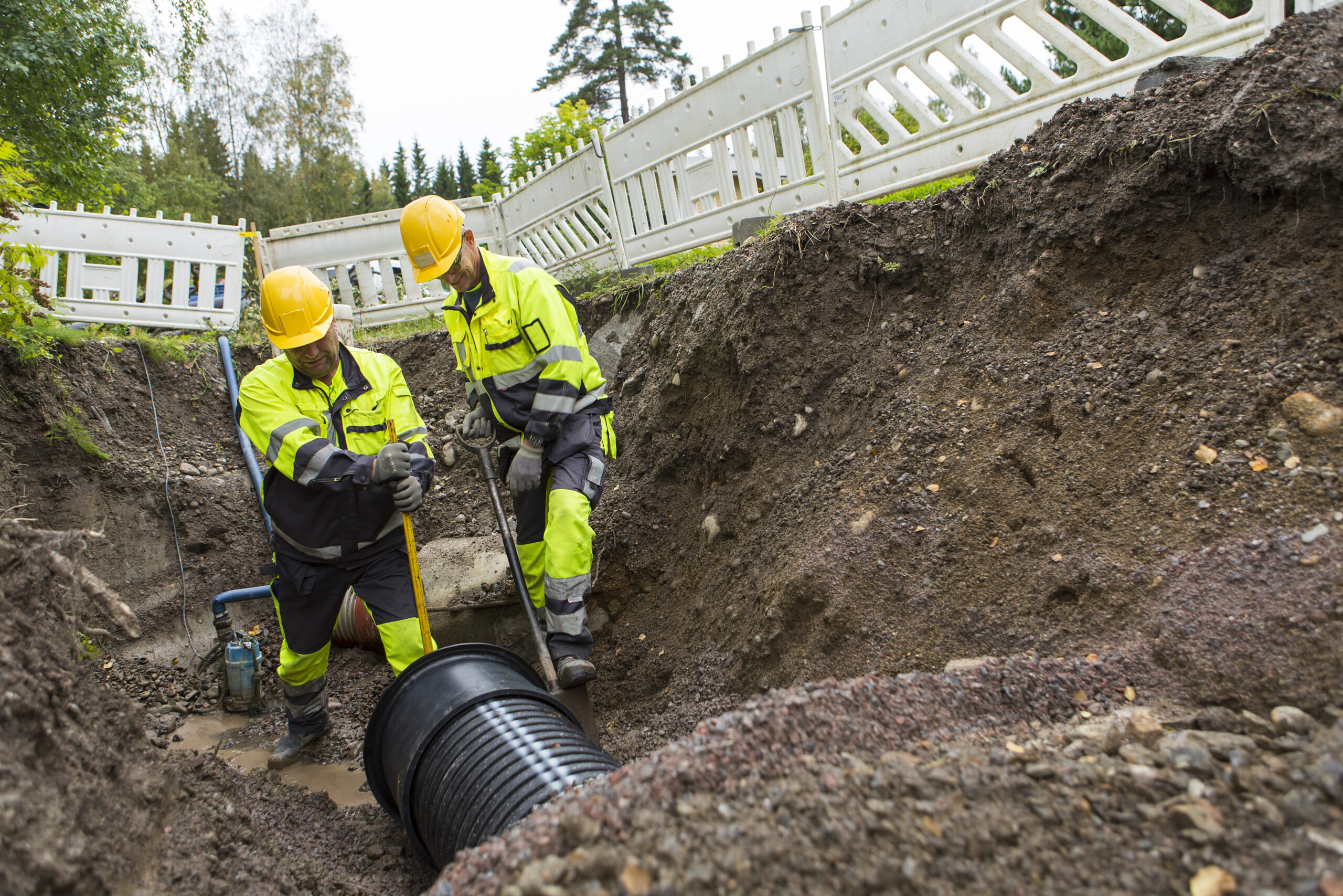 Kuvituskuva, jossa työmiehet asentavat vesijohtoa