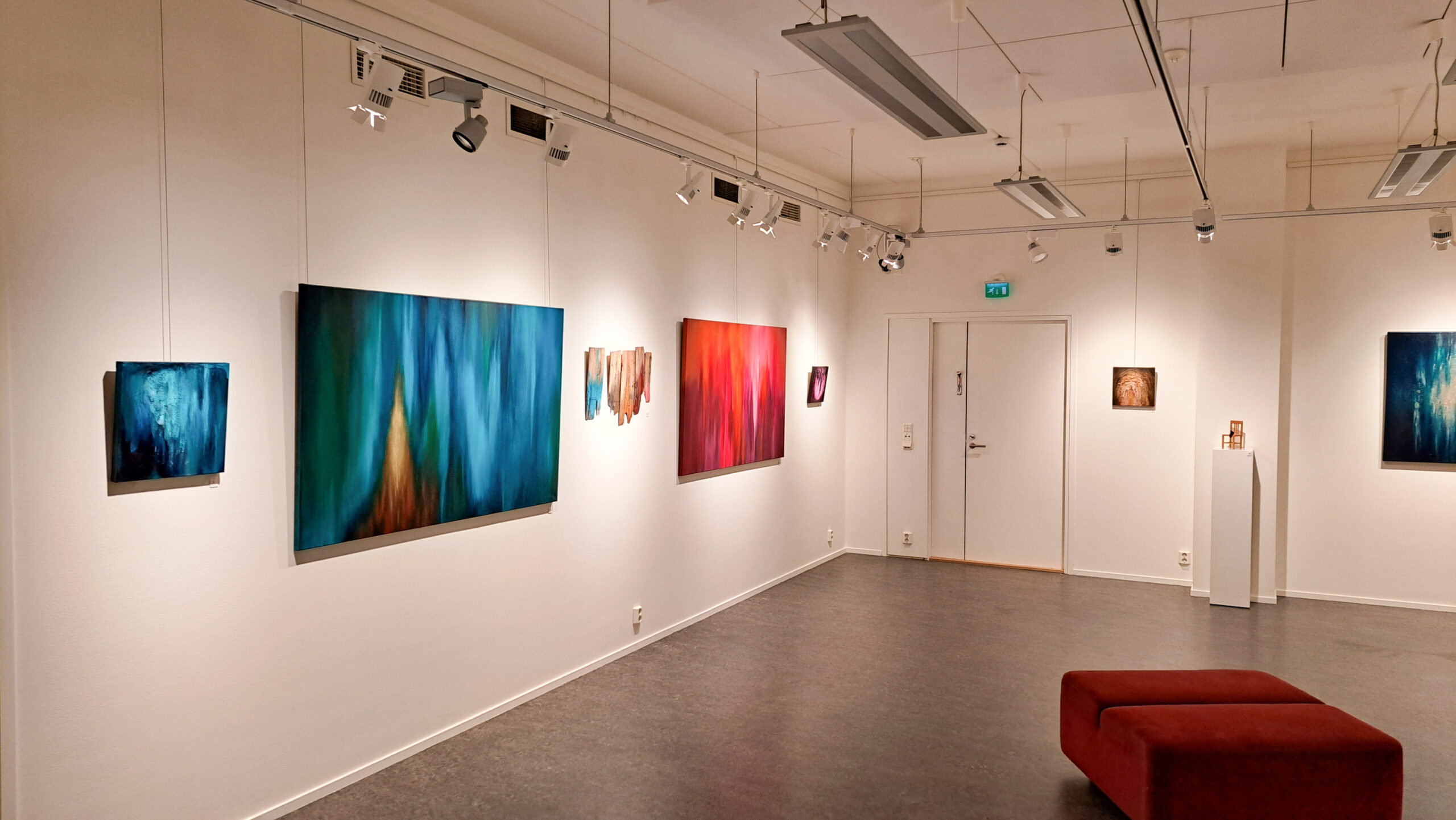 Taidetila Terran seinillä isoja, värikkäitä Marika Viskarin maalauksia.