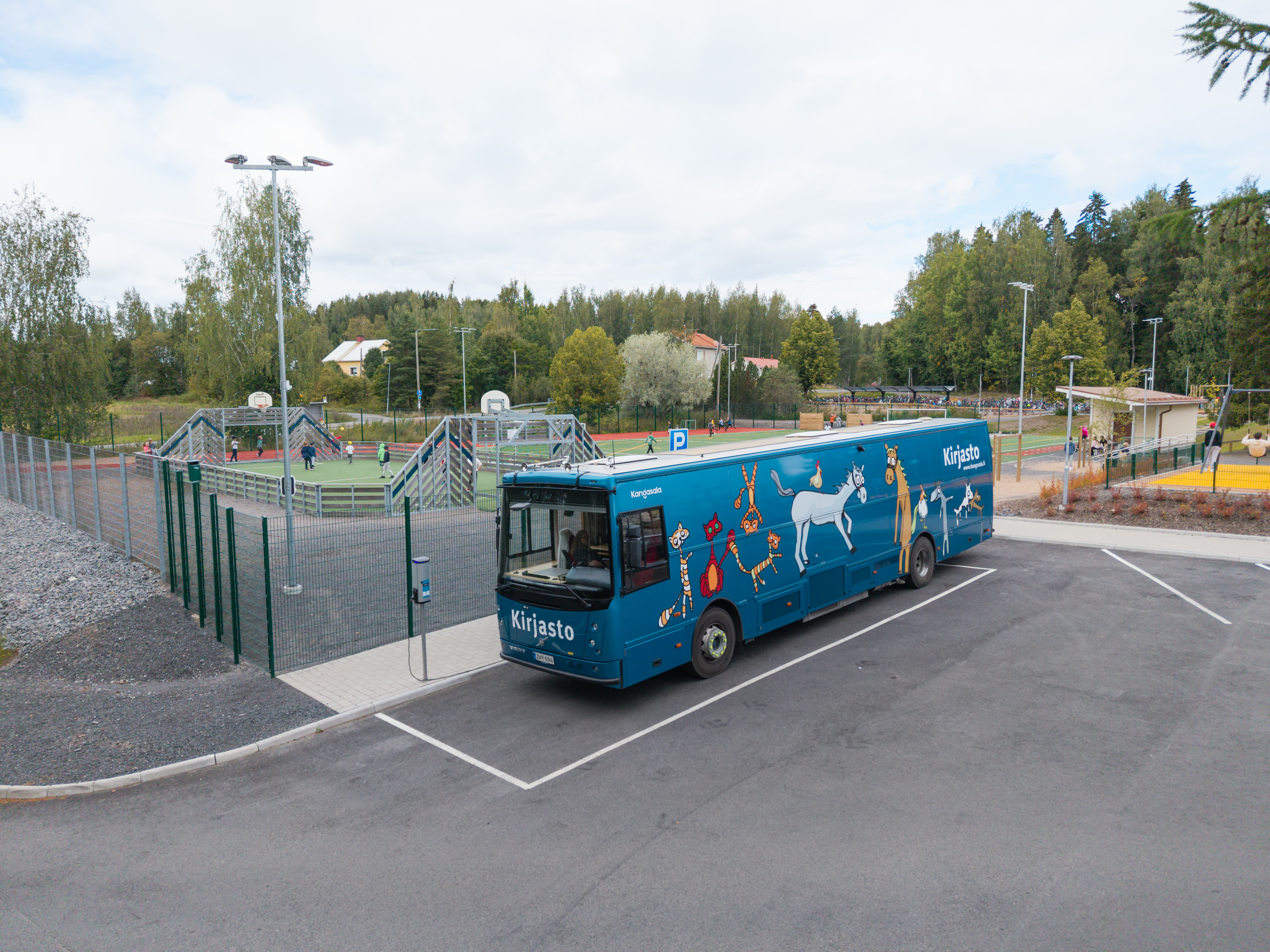 Kirjastoauto Kotikujan Konsta parkissa koulun pihalla.