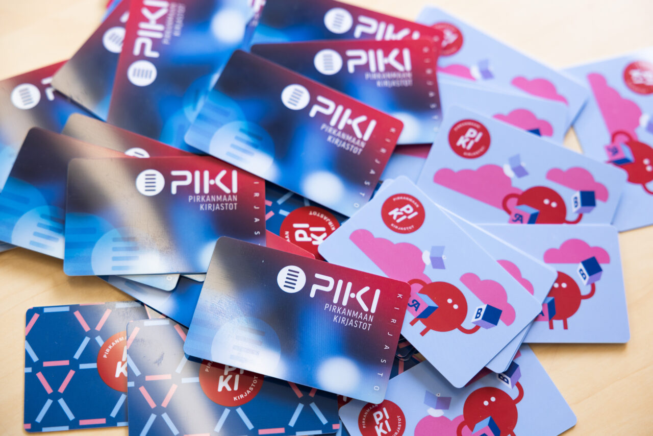 PIKI-alueen erilaisia kirjastokortteja sikin sokin pöydällä.
