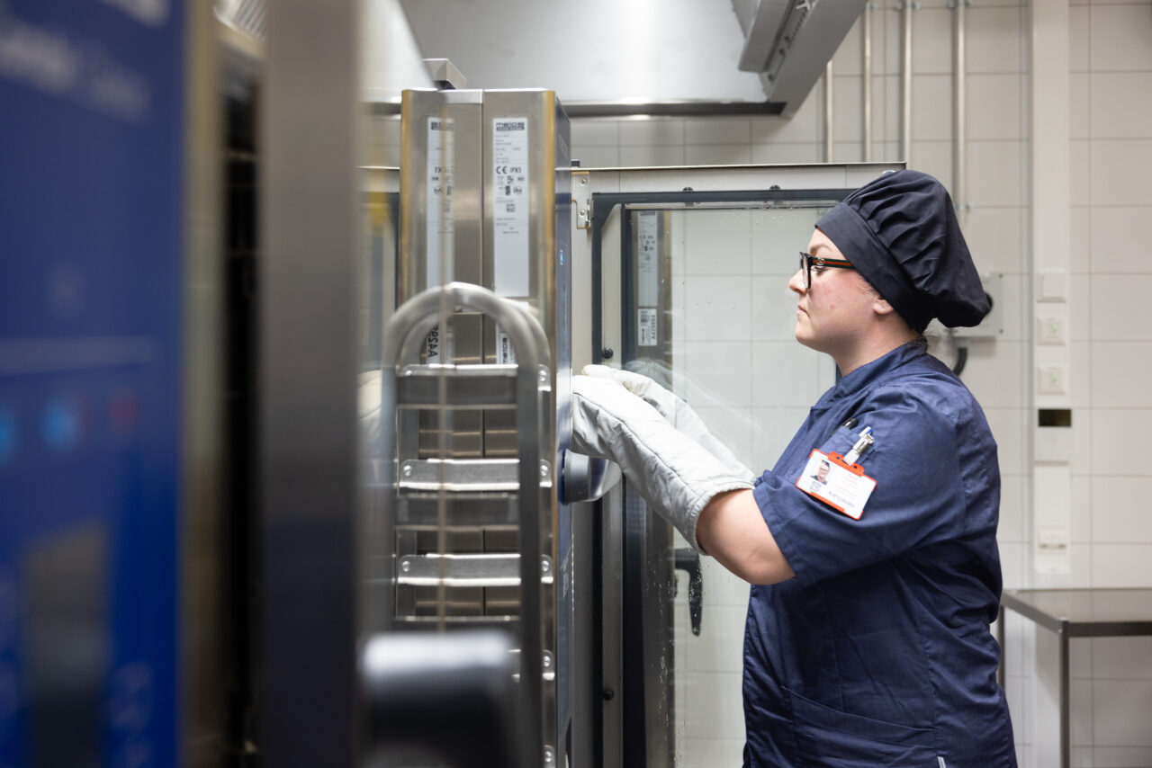 Kuvassa palvelutyöntekijä uunilla