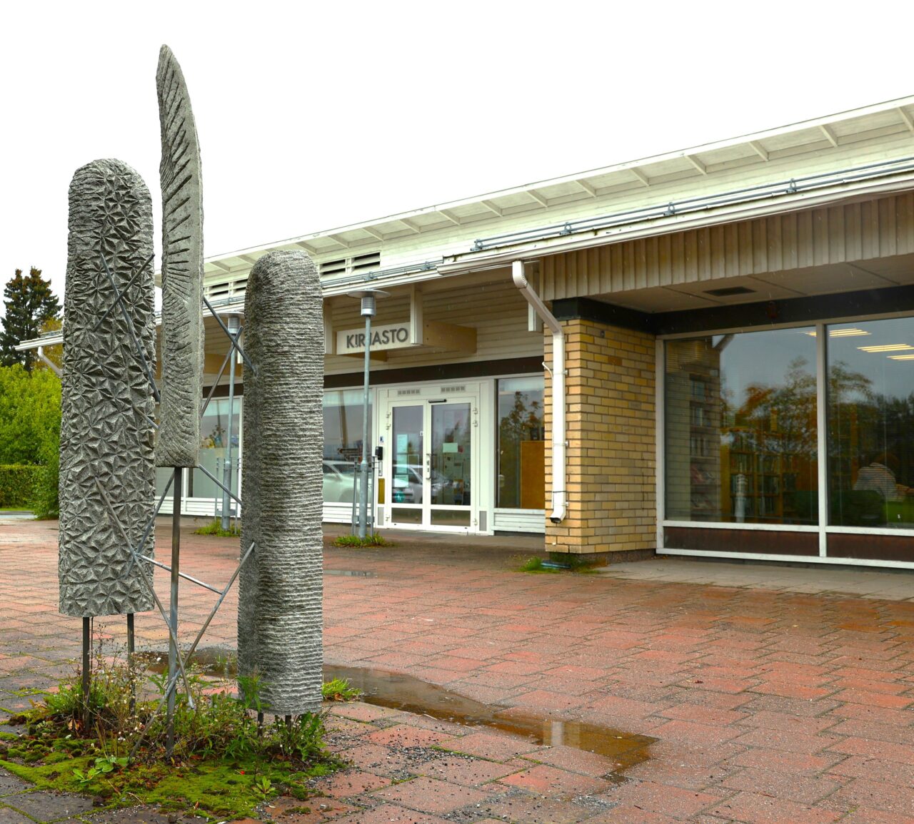 Sahalahden kirjasto ulkoa ja kirjaston edessä olevia patsaita.