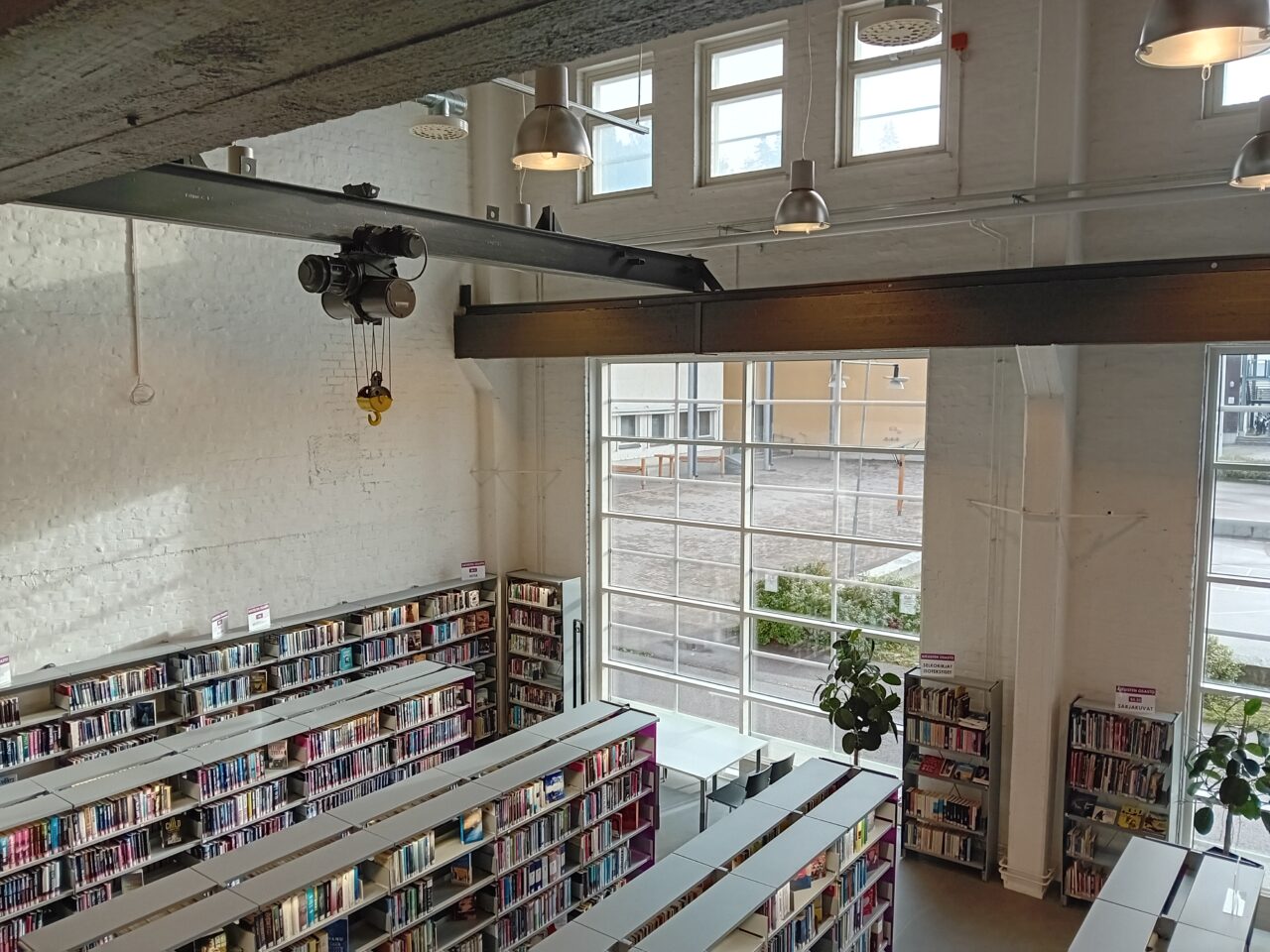 Vanhaan veturikorjaamon tehdyn Vatialan kirjaston kirjastosali ja hyllyjä sekä katossa vanhoja teollisuusrakenteita.