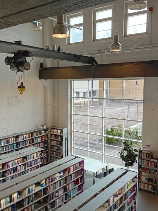 Vanhaan veturikorjaamon tehdyn Vatialan kirjaston kirjastosali ja hyllyjä sekä katossa vanhoja teollisuusrakenteita.
