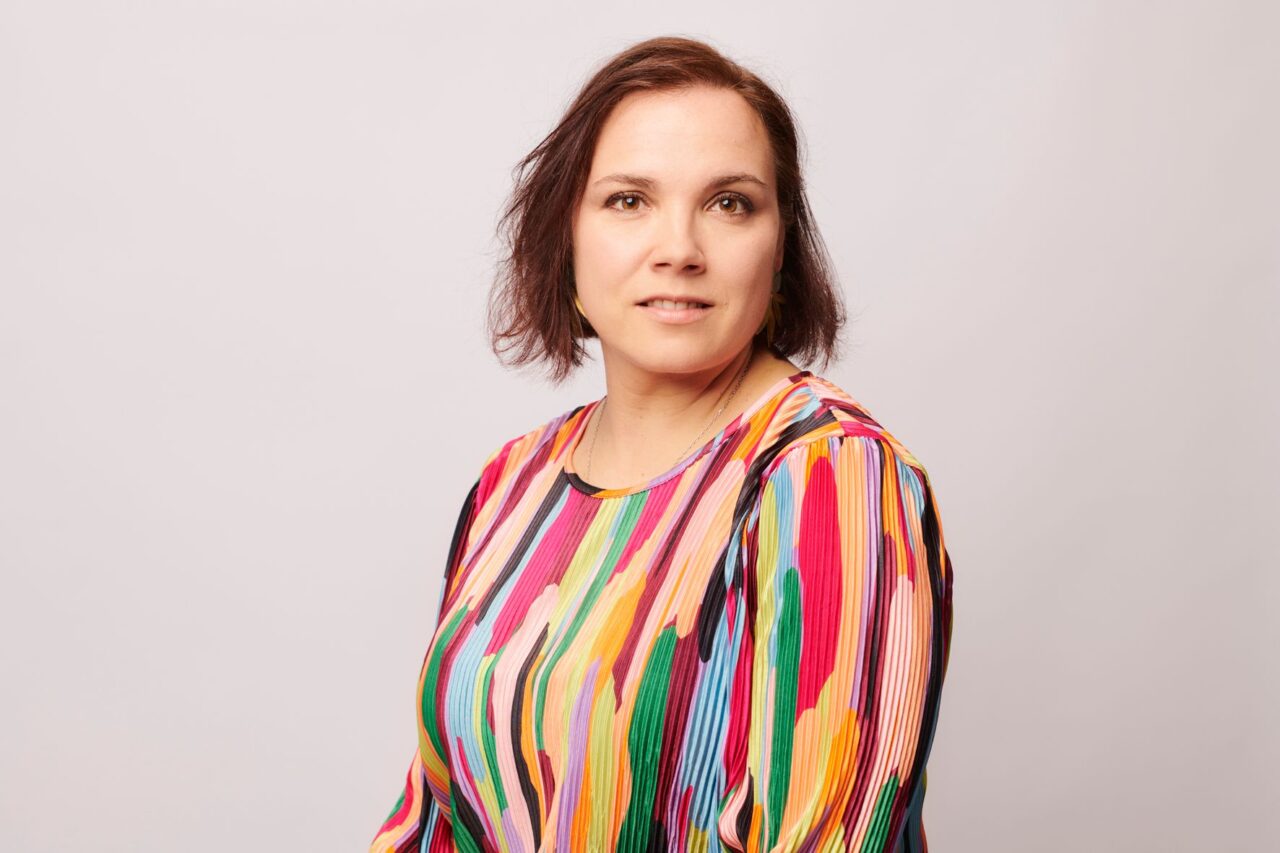 Kirjailija Anna Soudakova yllään värikäs paita.