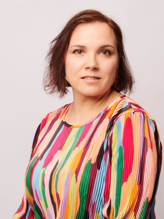 Kirjailija Anna Soudakova yllään värikäs paita.