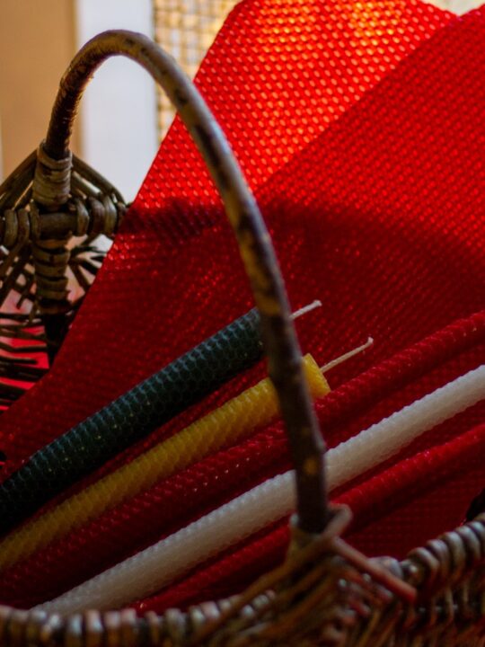 Mehiläisvahakynttilöitä korissa.