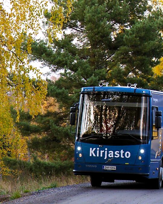 Kangasalan kirjastoauto maalaisreitillä. Ympärillä syksyisissä väreissä puita.
