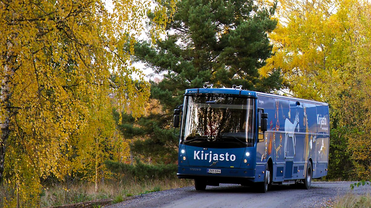 Kangasalan kirjastoauto maalaisreitillä. Ympärillä syksyisissä väreissä puita.