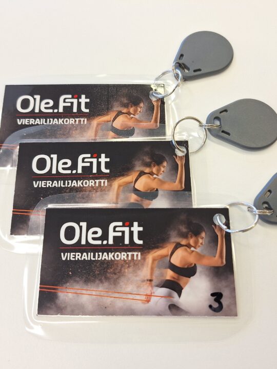Kolme kuntosalikorttia valkoisella pöydällä.