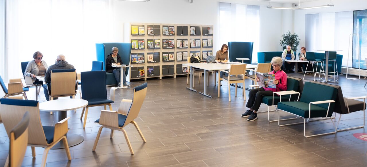 Kirjaston lehtisali, jossa asiakkaita lukemassa lehtiä.