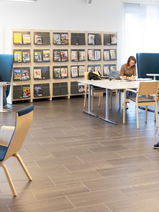 Kirjaston lehtisali, jossa asiakkaita lukemassa lehtiä.